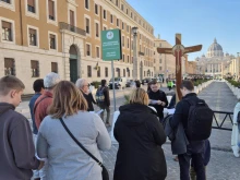 Marcin Bogacki of Warsaw, Poland (far right) prays before walking through the Holy Door of St. Peter's Basilica with his mother and 4-year-old son on Feb. 21, 2025.