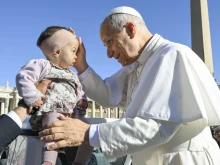 Pope Leo XIV blesses a baby in St. Peter’s Square during his general audience on Wednesday, Nov. 5, 2025, at the Vatican.