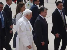 Pope Benedict walks across the tarmac with King Abdullah II