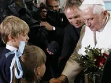 Pope Benedict is greeted by children at the airport in Vienna, Austria