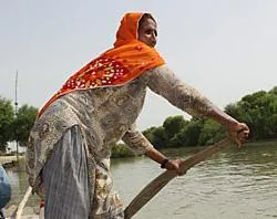 A woman rows a boat in Sindh, Pakistan, where swollen rivers swept away homes and destroyed crops and bridges. Photo by Laura Sheahen/CRS?w=200&h=150