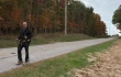 Father Gary Graf walks down a rural road during his trek across America in support of immigrants on Friday, Oct. 17, 2025.