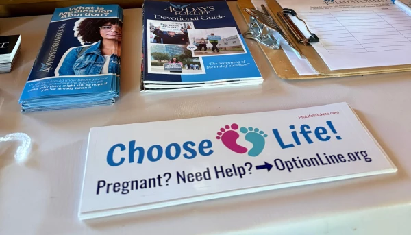 Gabriel Dionisi’s pro-life bumper sticker rests on an information table with other resources for pregnant women. Credit: Photo courtesy of Kevin Jorrey