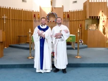 Twins baptized by twins — Gianna and Andrew Renwick with Father Ben and Deacon Luke Daghir.