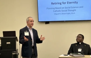 As Father Emmanuel Nanabanyin Conduah (right) looks on, PennWest University Professor Miguel Olivas-Luján (left) delivers his paper “Retiring for Eternity: Planning Based on Social Science and Catholic Social Thought” during the 2025 annual conference of the Society of Catholic Social Scientists at the Franciscan University of Steubenville. Credit: Ken Oliver-Méndez/CNA
