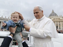 Pope Leo XIV greets a baby during his general audience in St. Peter’s Square at the Vatican on Wednesday, Oct. 22, 2025