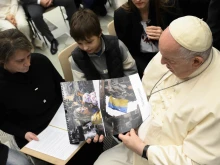 Pope Francis looking at images from Ukraine at the general audience, Dec. 21, 2022