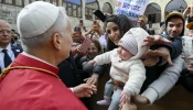 Pope Leo XIV greets a young mother and her child outside of the Monastery of St. Maron in Annaya, Lebanon, on Dec. 1, 2025.