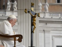 Pope Francis prays in front of a crucifix during his general audience on Oct. 26, 2022.