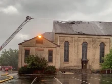 Firefighters work to put out a roof fire at historic St. James Catholic Church, in Rockford, Illinois, on Aug. 8, 2022. The Diocese of Rockford said a lightning strike was a possible cause.