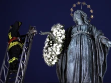 An Italian firefighter places a wreath of flowers on the statue of the Immaculate Conception in Rome’s Piazza di Spagna, Dec. 8, 2021.