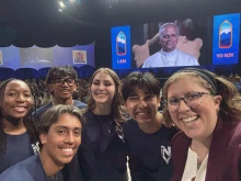 Teens Mia Smothers, Ezequiel Ponce, Micah Alcisto, Elise Wing, and Chris Pantelakis, and moderator Katie McGrady, right, take a “selfie” with Pope Leo XIV during a live digital encounter at Lucas Oil Stadium on Nov. 21, 2025.