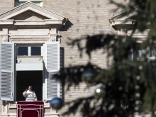 Pope Francis waves to pilgrims during his Angelus address on Dec. 17, 2023.