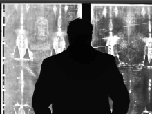 Filmmaker Robert Orlando, standing before a negative image of the Shroud of Turin, says he was prompted to investigate the purported burial cloth of Jesus in part because of a search to answer "big questions" about life and faith following the death of his father.
