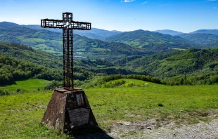 A cross stands in Montse Sole Historical Park in memorial of the victims of the massacres carried out there by Nazis in 1944. Credit: Francesco de Marco/Shutterstock