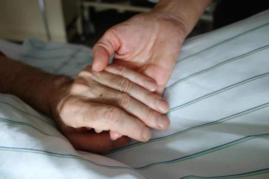 Nurse holding hand of patient. Stock photo via Shutterstock.?w=200&h=150