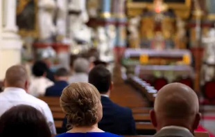People sitting in pews in church. Stock photo via Shutterstock. null