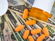 Prescription medicine on dollar bills. Via Shutterstock