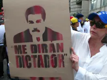 A woman holds a cartoon of Nicolas Maduro during opposition rally. 