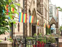 Gay Lesbian Pride Rainbow Flags on Church Building in City. 