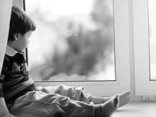 Child looks out of the window. 