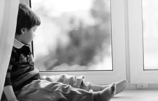 Child looks out of the window.   alexkich_Shutterstock
