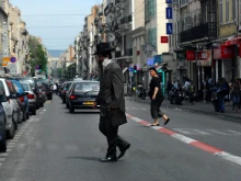 An Orthodox Jewish man cross the street in Marseille, France. ChameleonsEye / Shutterstock
