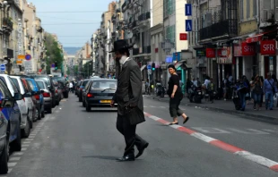 An Orthodox Jewish man cross the street in Marseille, France. ChameleonsEye / Shutterstock