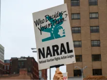 activist carrying a NARAL (National Abortion Rights Action League) sign at a pro abortion rally. 