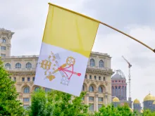 Flag of Vatican City on display in front of the Palace of Parliament in Bucharest, during Pope Francis 2019 visit in Romania. Via Shutterstock