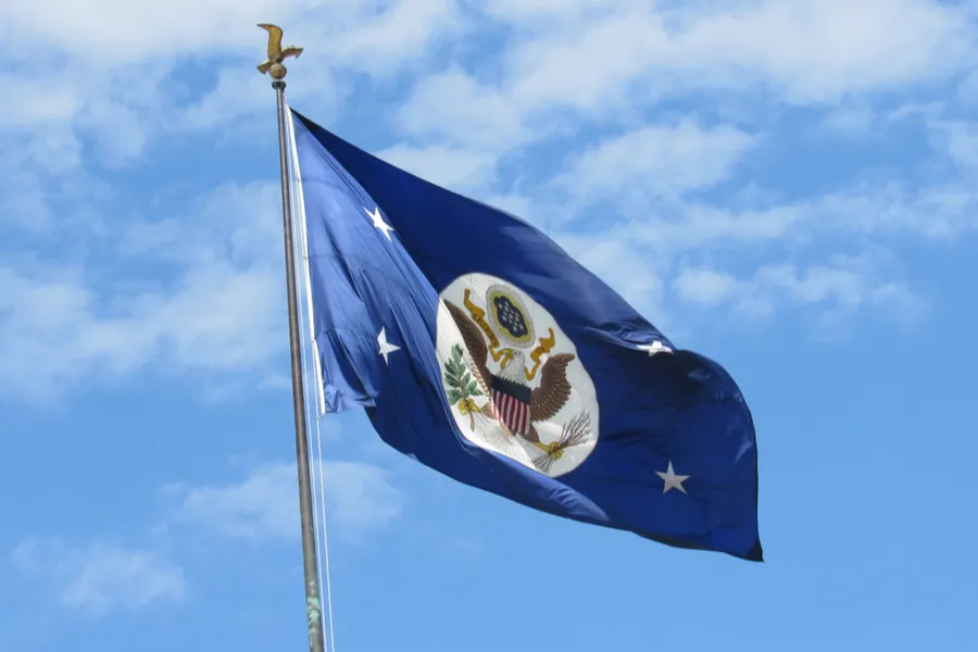 A blue flag with the official seal of the U.S. government flies over the headquarters of the Department of State in Foggy Bottom. Via Shutterstock?w=200&h=150