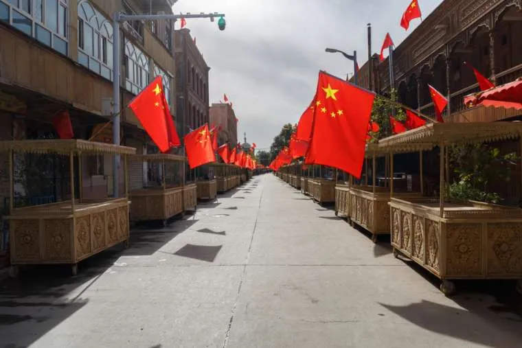 Street with market stalls with Chinese flags on every booth, Xinjiang, China. ?w=200&h=150