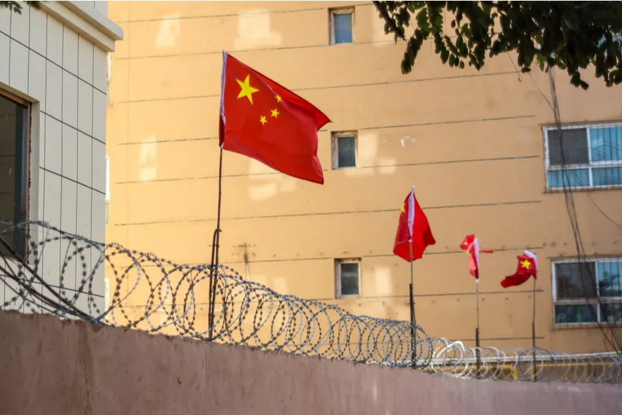 Chinese flags on barbed wired wall in Kashgar (Kashi), Xinjiang, China. Credit: Jonathan Densford/Shutterstock?w=200&h=150