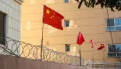 Chinese flags on barbed wired wall in Kashgar (Kashi), Xinjiang, China.