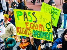 A participant in a Women's March event Jan. 18, 2020, in San Francisco holds a "Pass the Equal Rights Amendment" sign while marching.