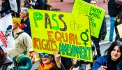 A participant in a Women's March event Jan. 18, 2020, in San Francisco holds a "Pass the Equal Rights Amendment" sign while marching.