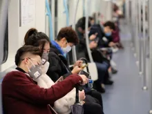 People wearing surgical mask sitting in subway in Shanghai, China. 