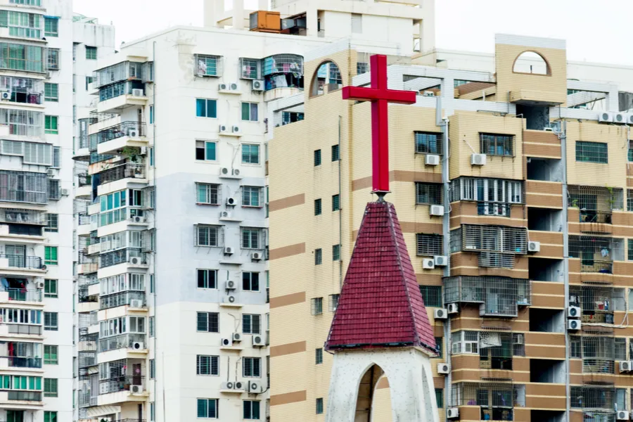Church cross against city background in China. ?w=200&h=150