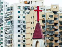 Church cross against city background in China. 