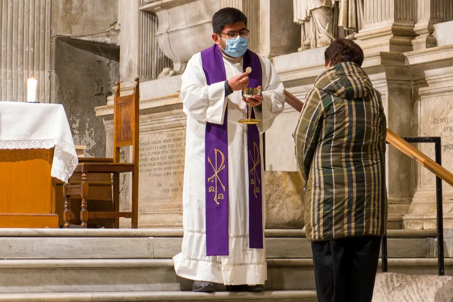 Priest distributes communion at the church of Santa Maria in Trastevere, Rome. ?w=200&h=150