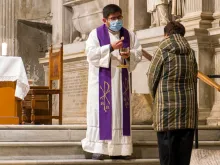Priest distributes communion at the church of Santa Maria in Trastevere, Rome. 