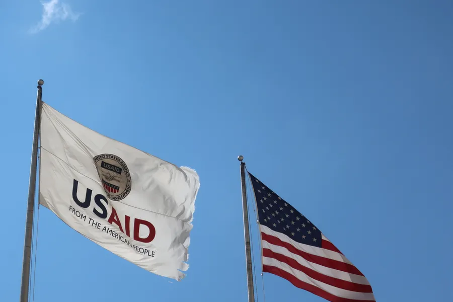 USAID Agency for International Development flag with emblem seal outside headquarters building. ?w=200&h=150