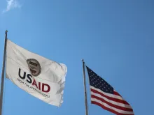 USAID Agency for International Development flag with emblem seal outside headquarters building. 
