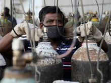 A worker refills medical oxygen cylinders for COVID-19 patients in New Delhi, India.