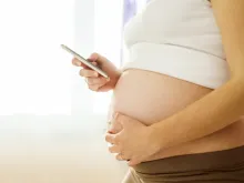 Pregnant woman with mobile phone. Via Shutterstock