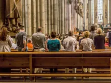 People in the pews at Cologne Cathedral, Germany. 
