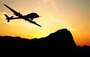 Drone flying over mountains on sunset background. Via Shutterstock 