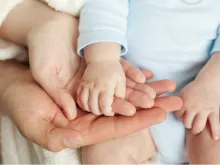 Parents holding child's hand. 