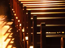 Rows of pews in a church building. 