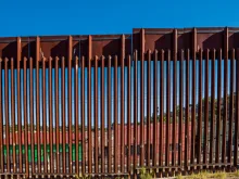 Closeup of border fence between US and Mexico in Nogales, Arizona. Via Shutterstock.